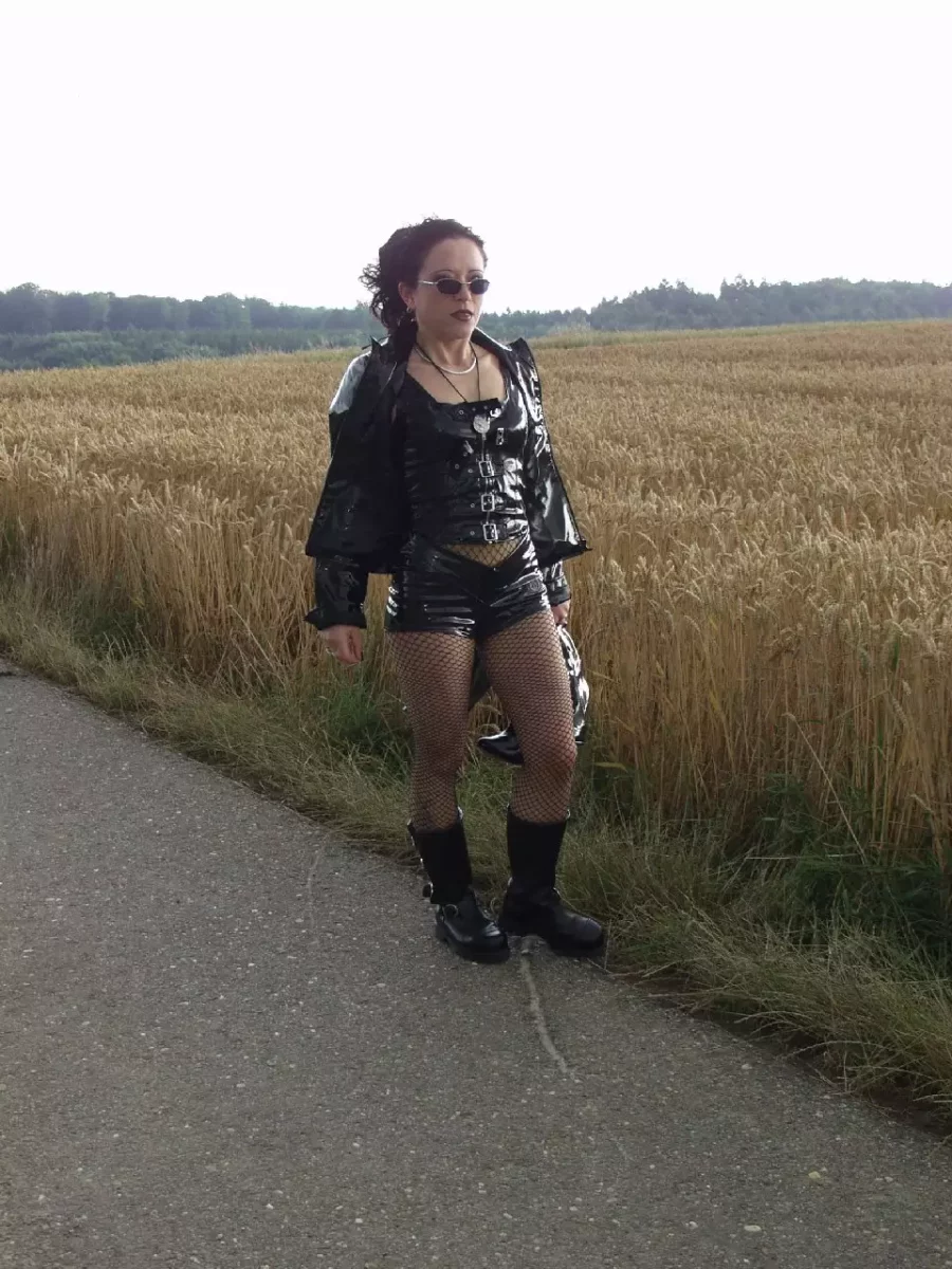 Frau im Latex Outfit auf einem Feldweg